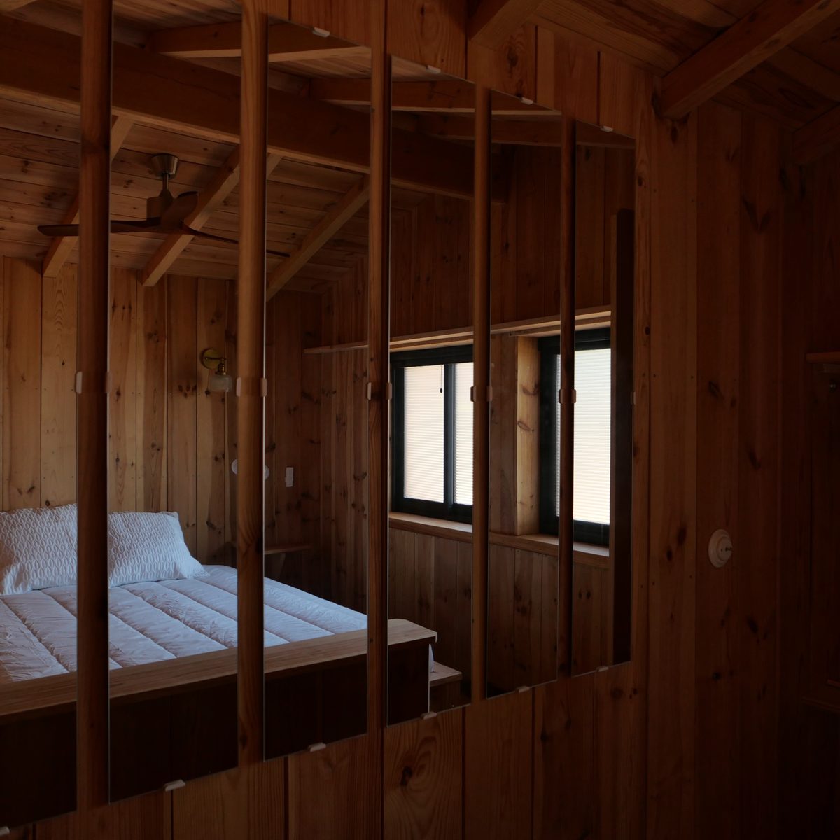Chambre aperçue à travers un panneau de miroirs